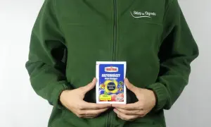 Osoba w zielonej bluzie trzyma opakowanie środka grzybobójczego SYLLIT 65 WP. Produkt przeznaczony jest do ochrony drzew owocowych.