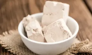 Kostki świeżych drożdży w miseczce, gotowe do użycia jako naturalny nawóz z drożdży dla roślin.