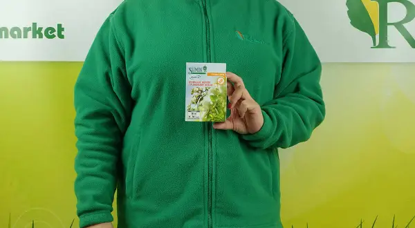 Kobieta w zielonej bluzie trzyma opakowanie stymulatora wzrostu roślin. Na opakowaniu widnieje napis "SUMIN ASAMI SL", a pod nim "STYMULUJE WZROST I PLONOWANIE ROŚLIN". Informacje o dawkowaniu są widoczne na dole.