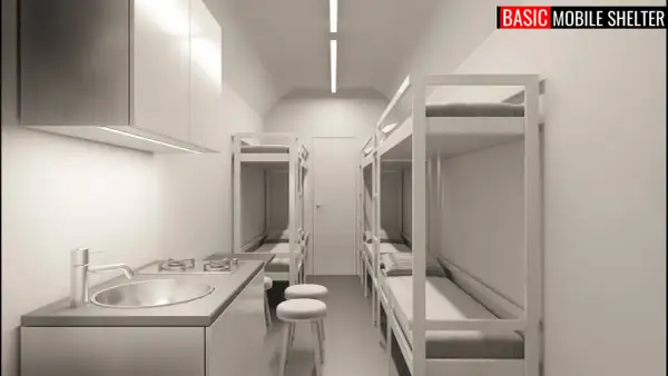 Wnętrze taniego schronu przydomowego z aneksem kuchennym i łóżkami piętrowymi.